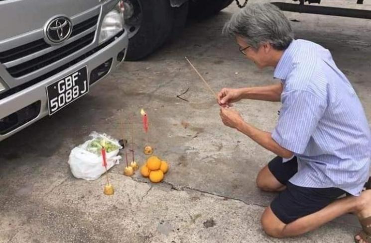 Pria paruh baya yang cari wangsit dengan memberi plat nomor mobil sesajen. (Facebook/Xionk Qhing)