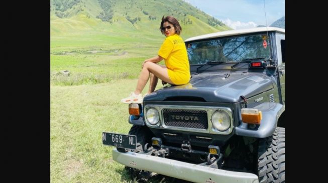 Dinar Candy pose di atas kap mesin (Instagram)